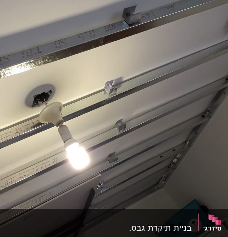 תקרת גבס עם פרופילי מתכת ונורה תלויה